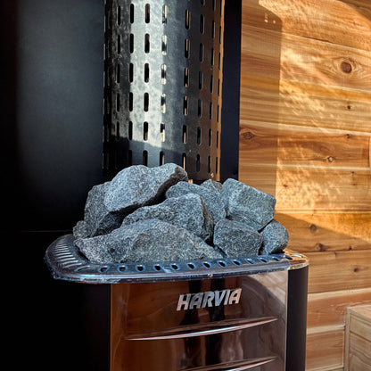 Harvia sauna stove with rocks inside a wooden sauna room.